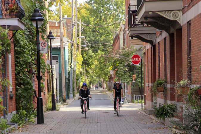 Cyclists riding through an alley way in Montreal